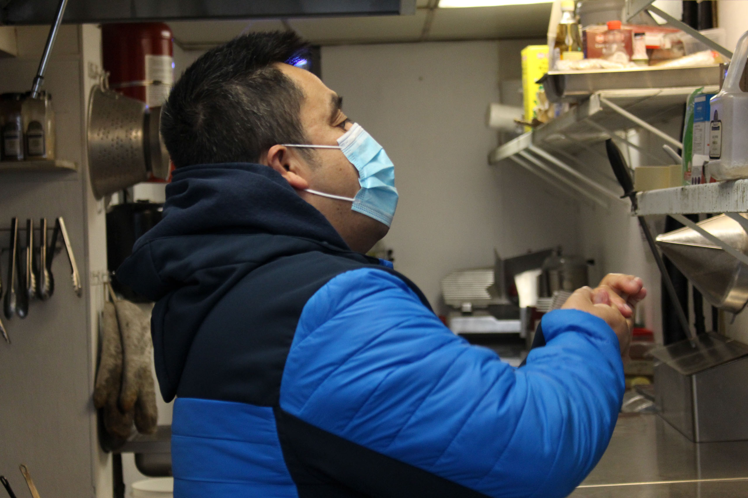 Francisco Melgar applies hand sanitizer before putting on gloves in the kitchen of Bottlescrew Bill’s before starting his cleaning duties in Calgary on April. 15, 2021. Melgar was laid off officially from the Sheraton Eau Claire, the place he worked for for 15 years, back in October of 2020, after being on a leave as a result of the COVID-19 pandemic. He was the assistant to the power engineer. (Photo by Alejandro Melgar/SAIT)